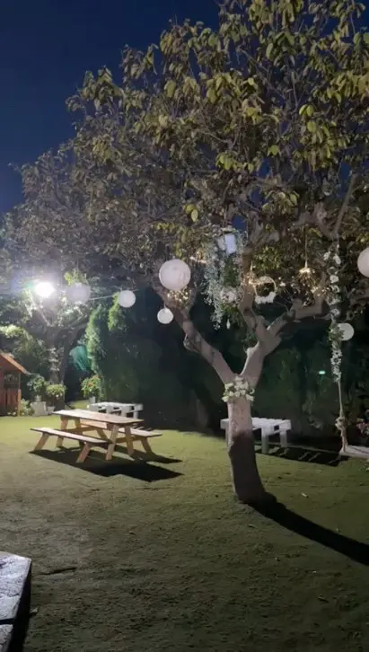 El jardín de Villa Meli iluminado con farolillos y guirnaldas de luces al anochecer