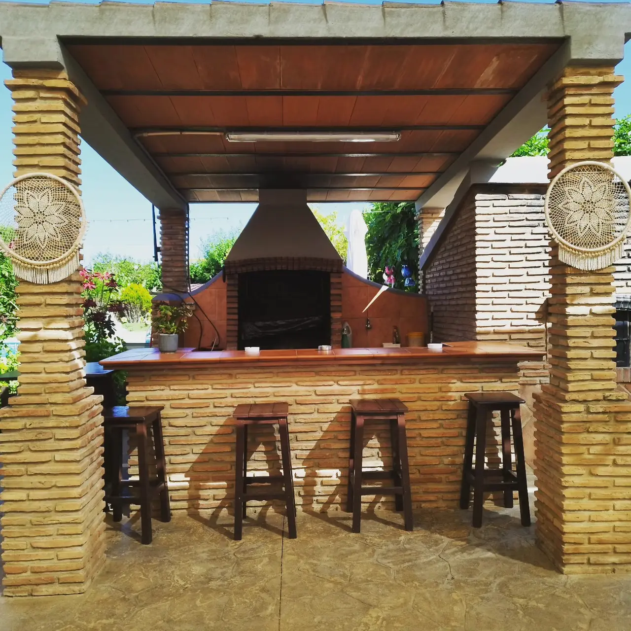 Porche de Villa Meli con barbacoa de obra, campana y barra con taburetes