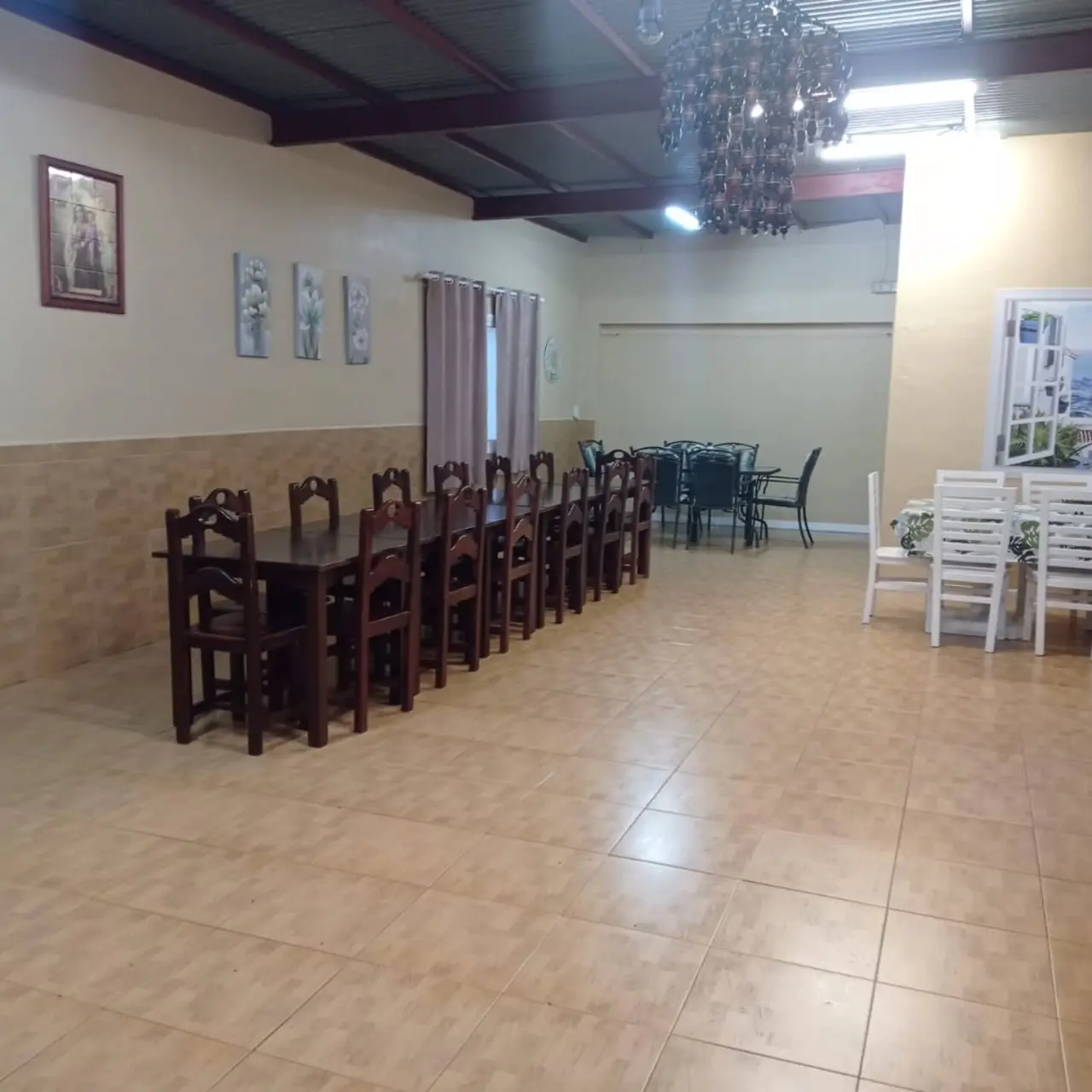 Amplio salón comedor de Villa Meli con mesas y sillas para celebraciones